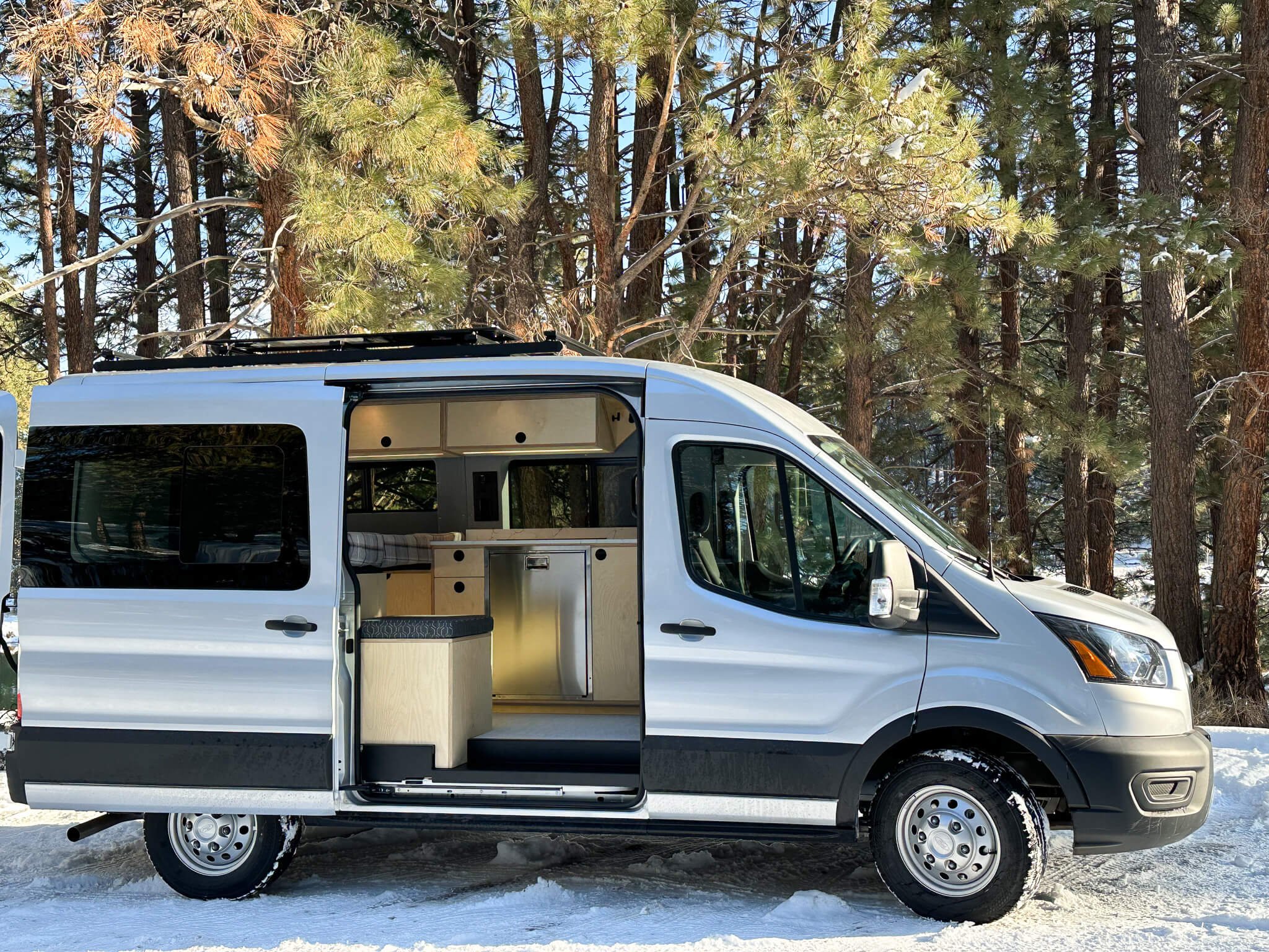 Side view of 'Silver Linings' Ford Transit van with open side door, displaying custom HWA interior.