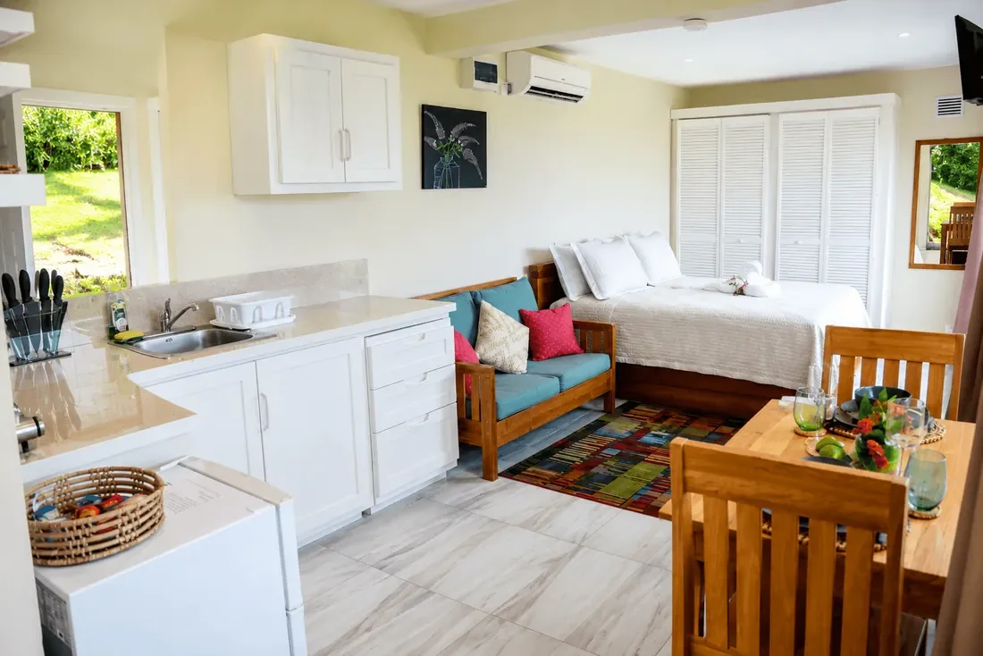Open-plan studio apartment in Coubaril, Saint Lucia, with a kitchenette, bed and dining area