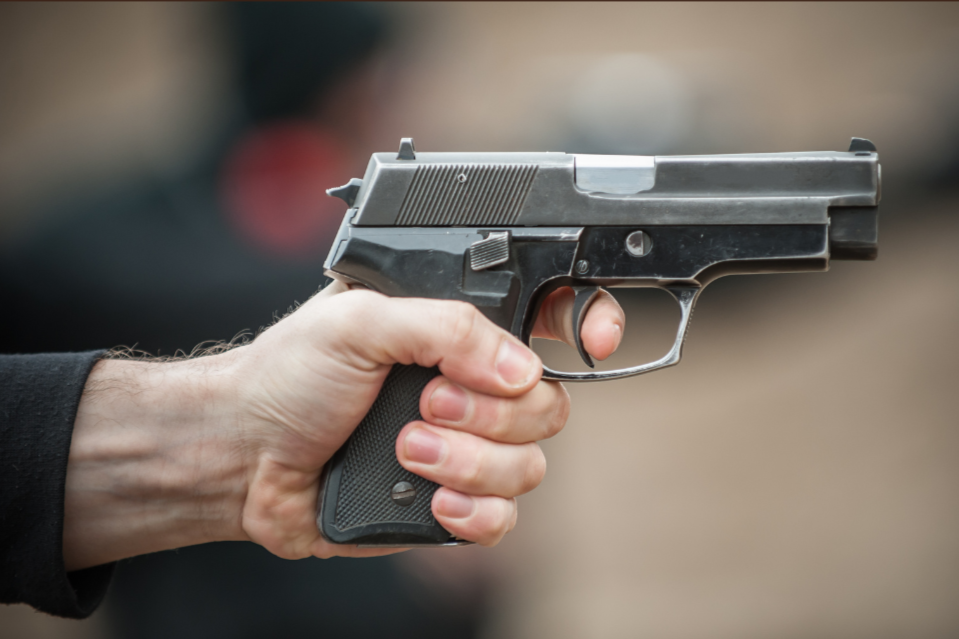 person gripping pistol with non-dominant hand