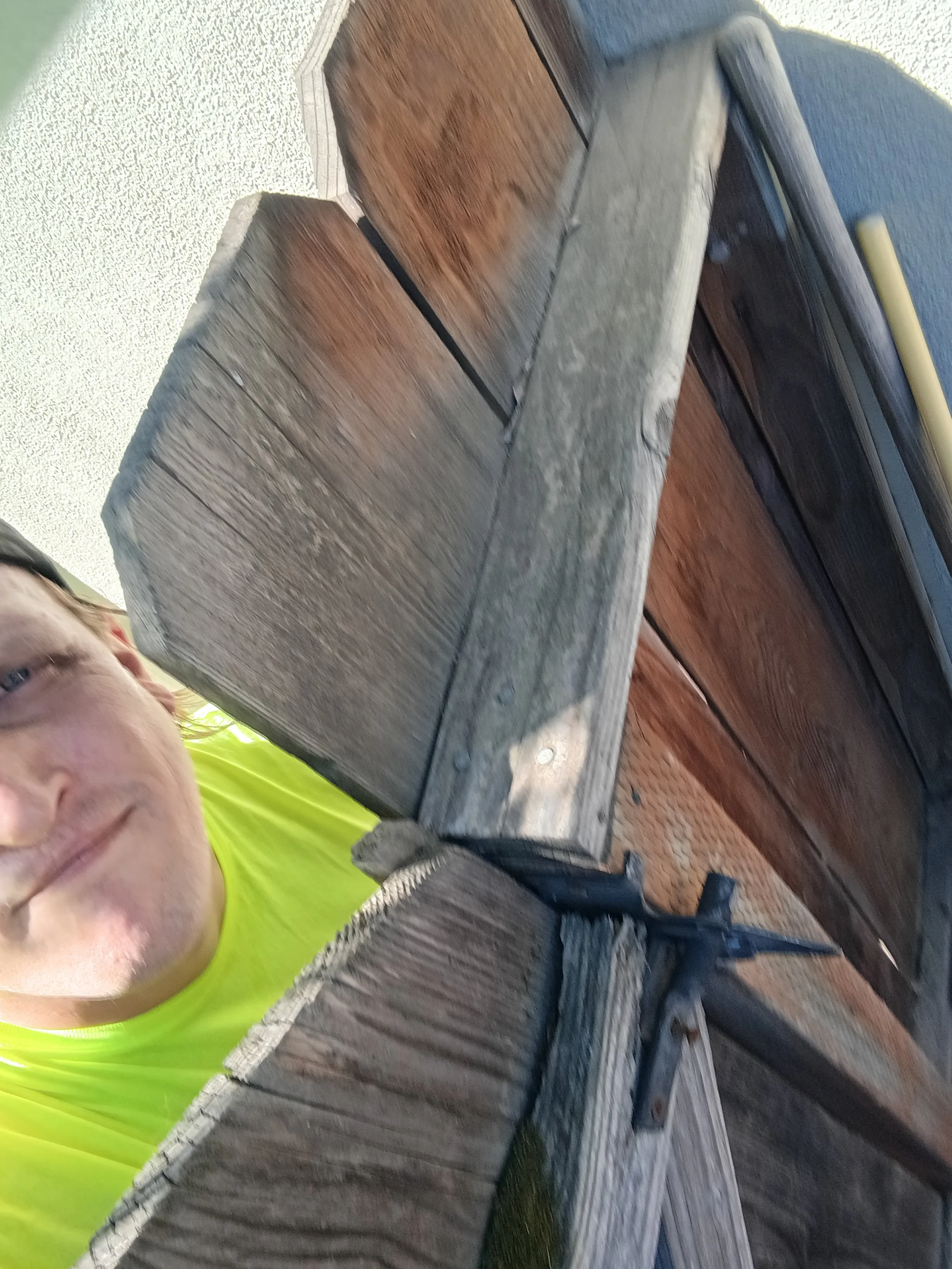 Poop Scoop Champion owner Andrew confirming that a customer’s wooden backyard gate is securely closed after dog waste removal service.