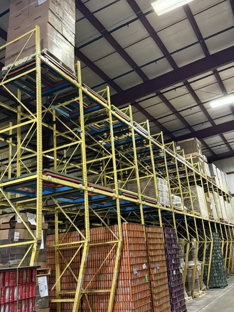 Industrial warehouse shelving with stacks of boxes and pallets.