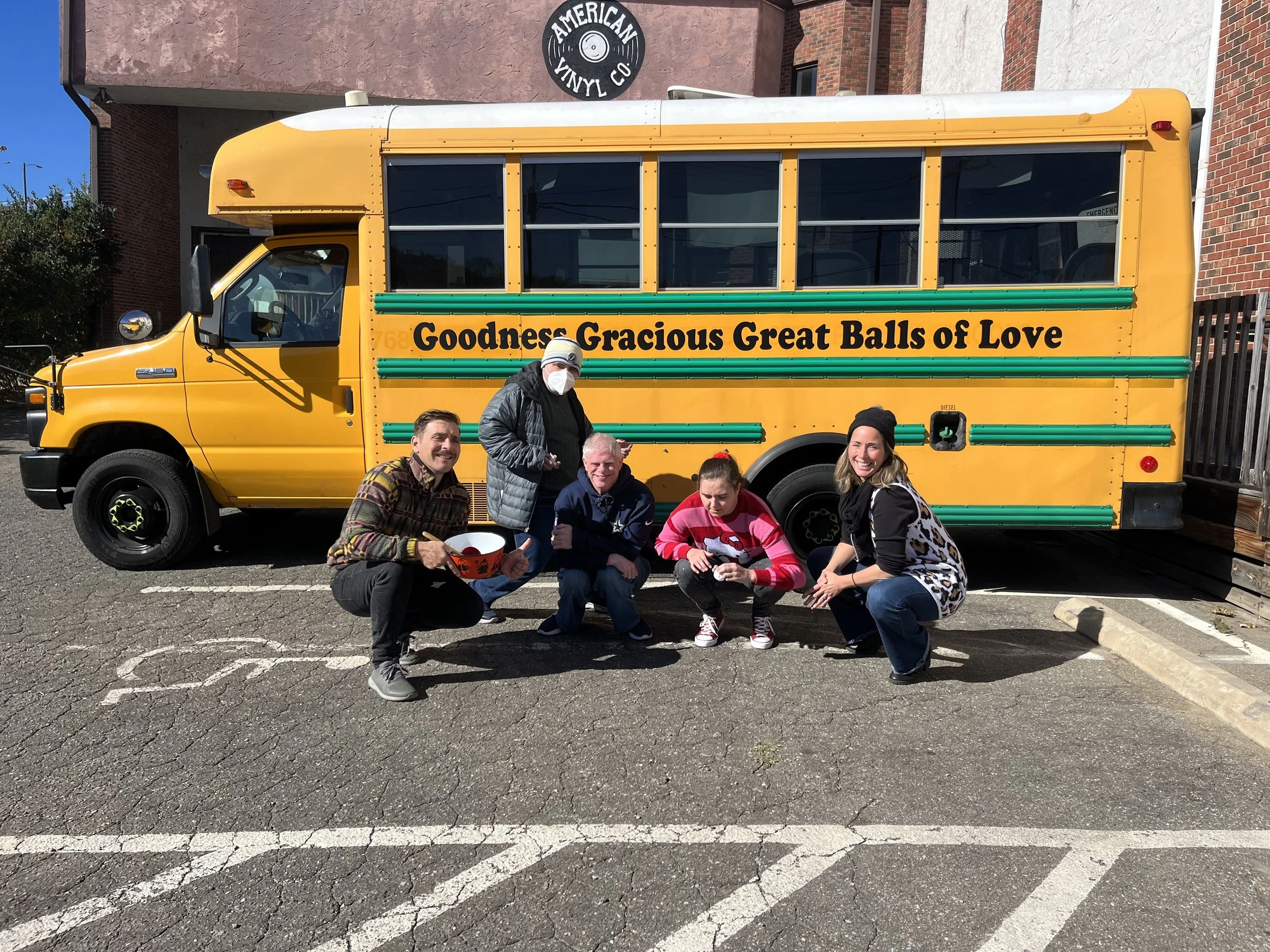 Participants celebrate completing a hands-on hospitality training session with Great Balls of Love's mobile training kitchen.