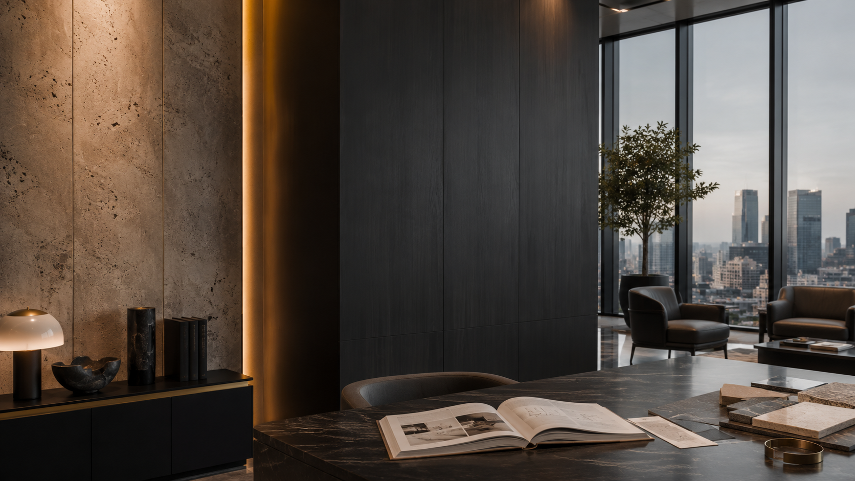 Modern office with large windows overlooking a city skyline, a marble table with open books and design samples, black leather armchairs, a small potted tree, and a console with decorative objects and books.
