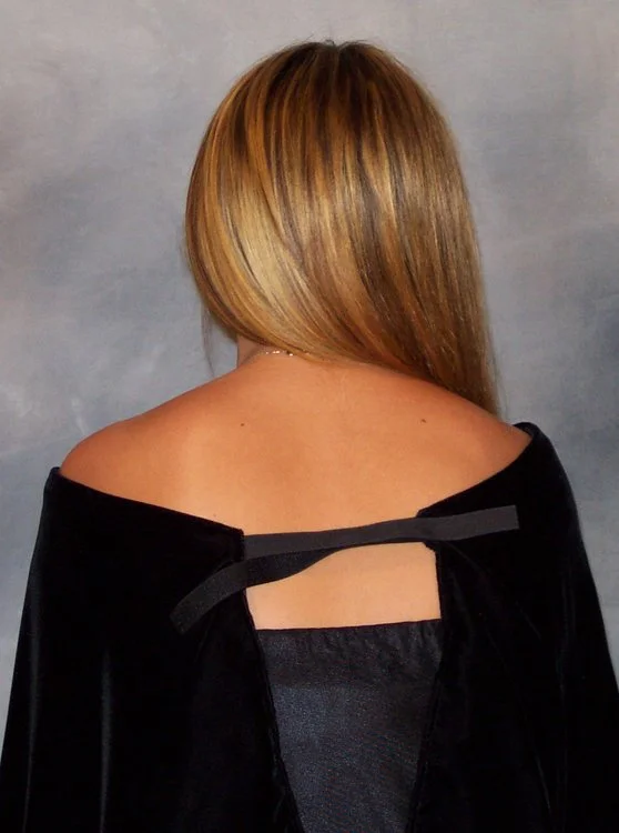 Back view of an adjustable black velvet senior portrait drape fastened with a hook-and-loop closure