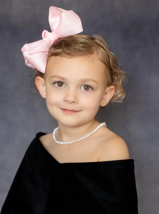 Child-size black velvet portrait drape with a classic off-the-shoulder neckline