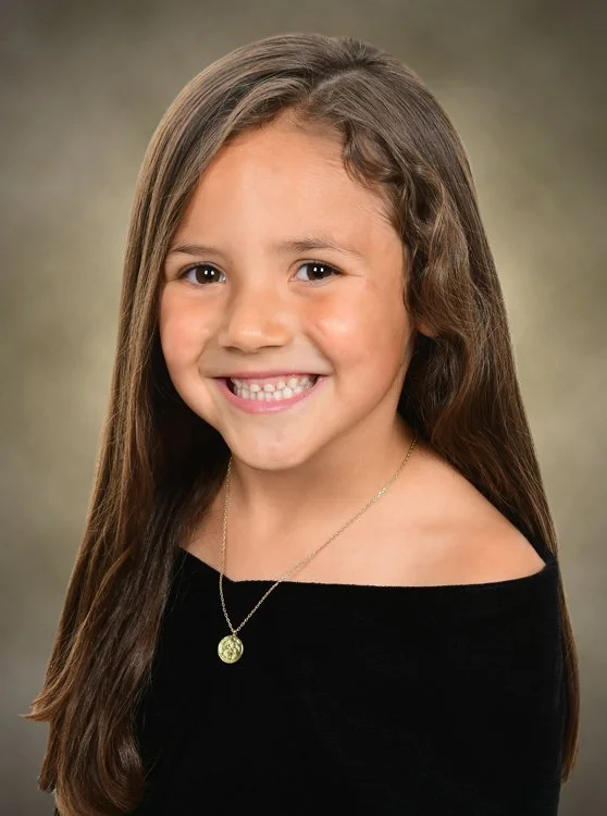 Portrait of a preschool student in a black velvet drape