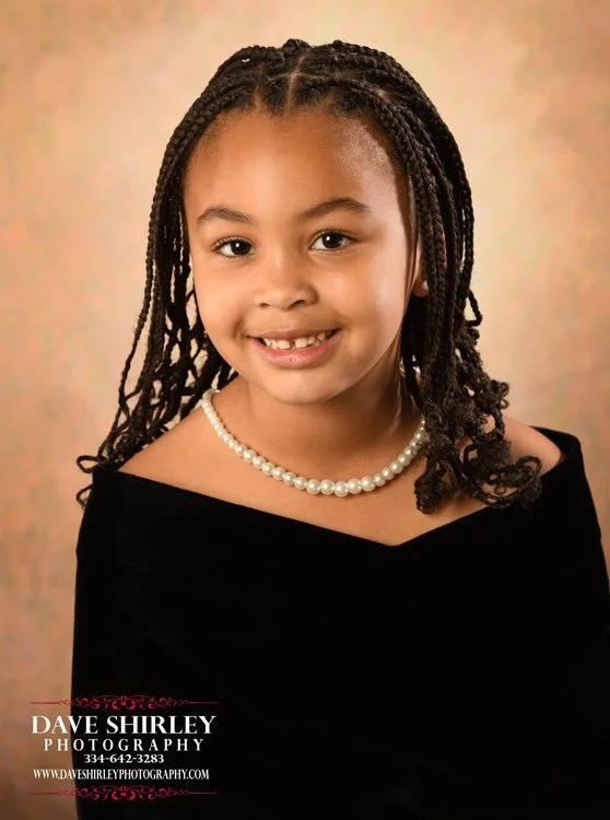 Preschool student wearing a black velvet photography drape
