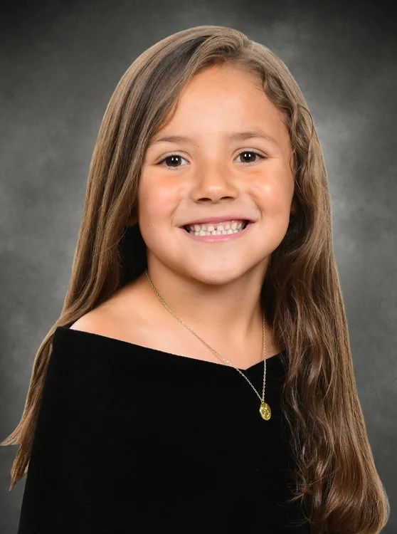 Preschool graduation portrait featuring a child-size black drape