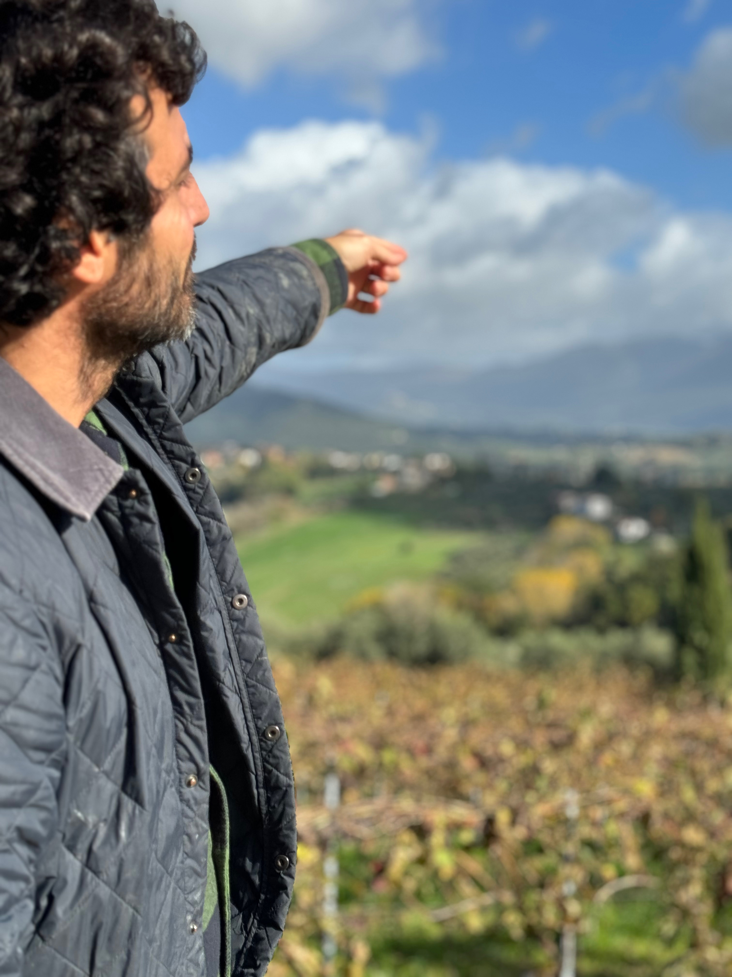Winemaker Leo Sassi pointing toward the Sabine Hills in Tarano, Lazio, Italy.