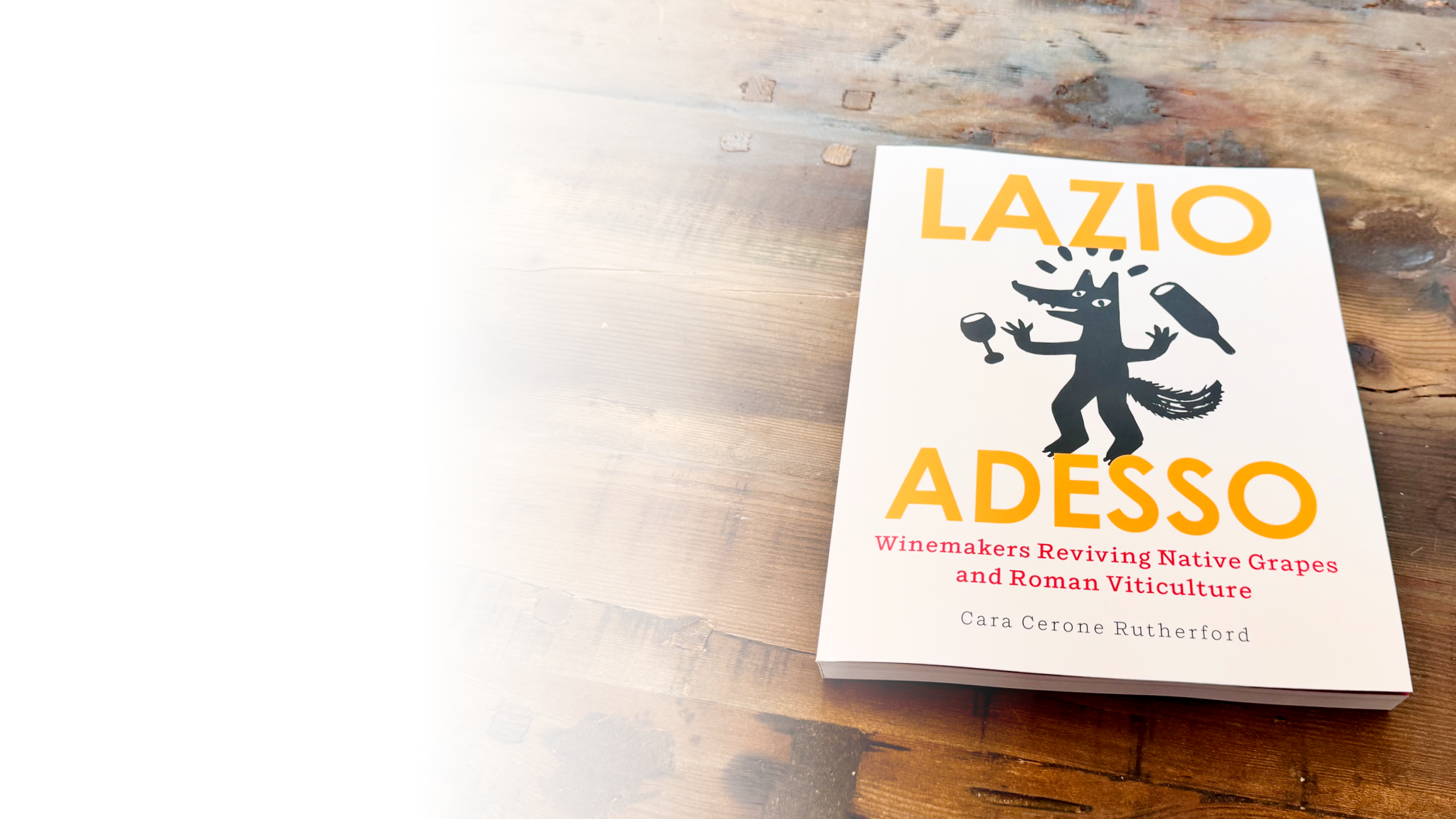 Cover of Lazio Adesso: Winemakers Reviving Native Grapes and Roman Viticulture by Cara Cerone Rutherford on a wooden table.