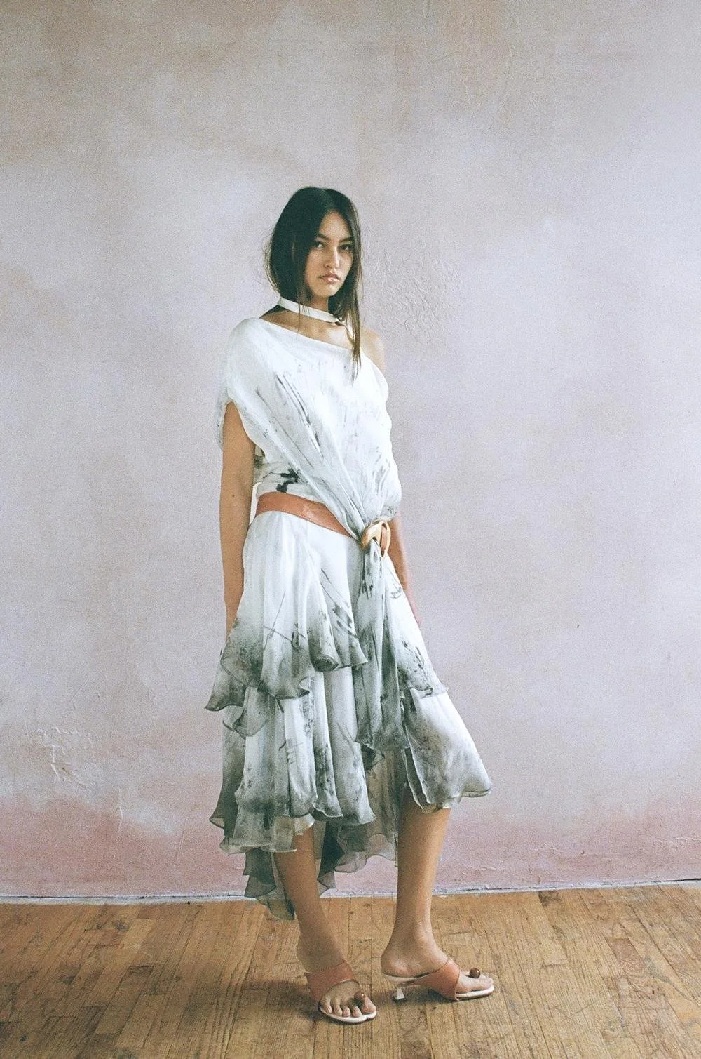 Bias cut three tiered silk chiffon dress with laser cut stencil air brushing, used to mimic age and driftwood motifs. Reclaimed leather belt with wooden band saw cut utility buckle to create drape across the chest, with matching customized wooden orb