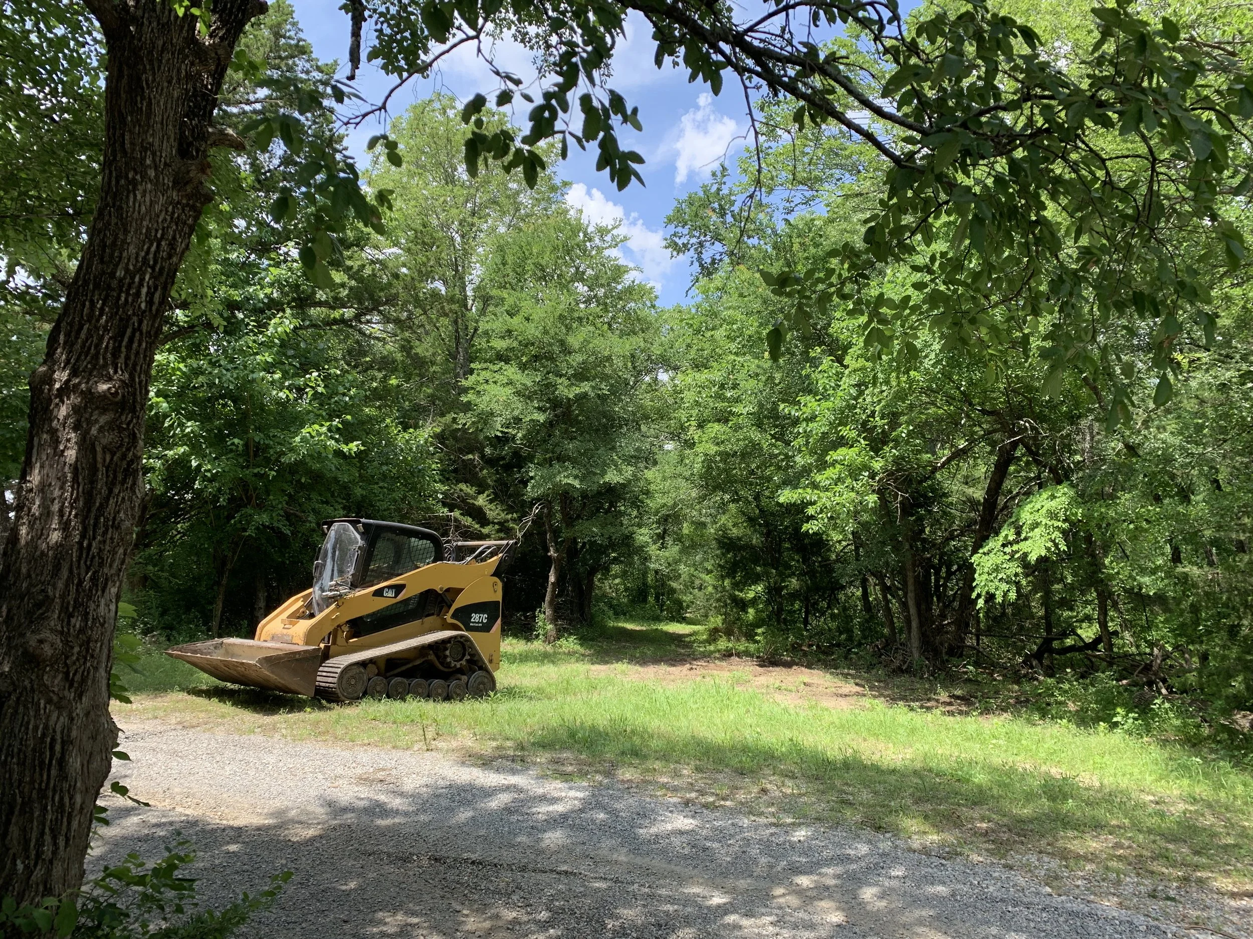 Caterpillar 287C skid steer with forestry mulcher on a Texoma-area job site