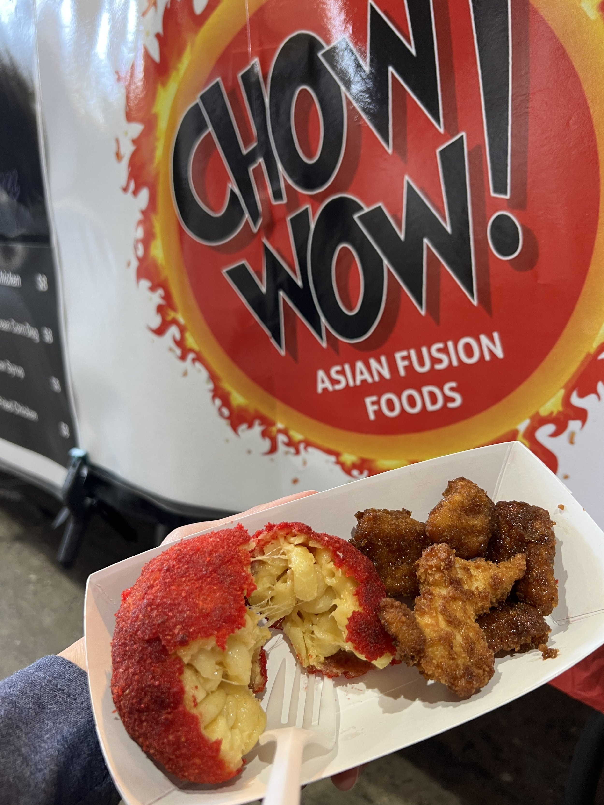 Close-up of a paper food tray with fried chicken and a red balm apple.
