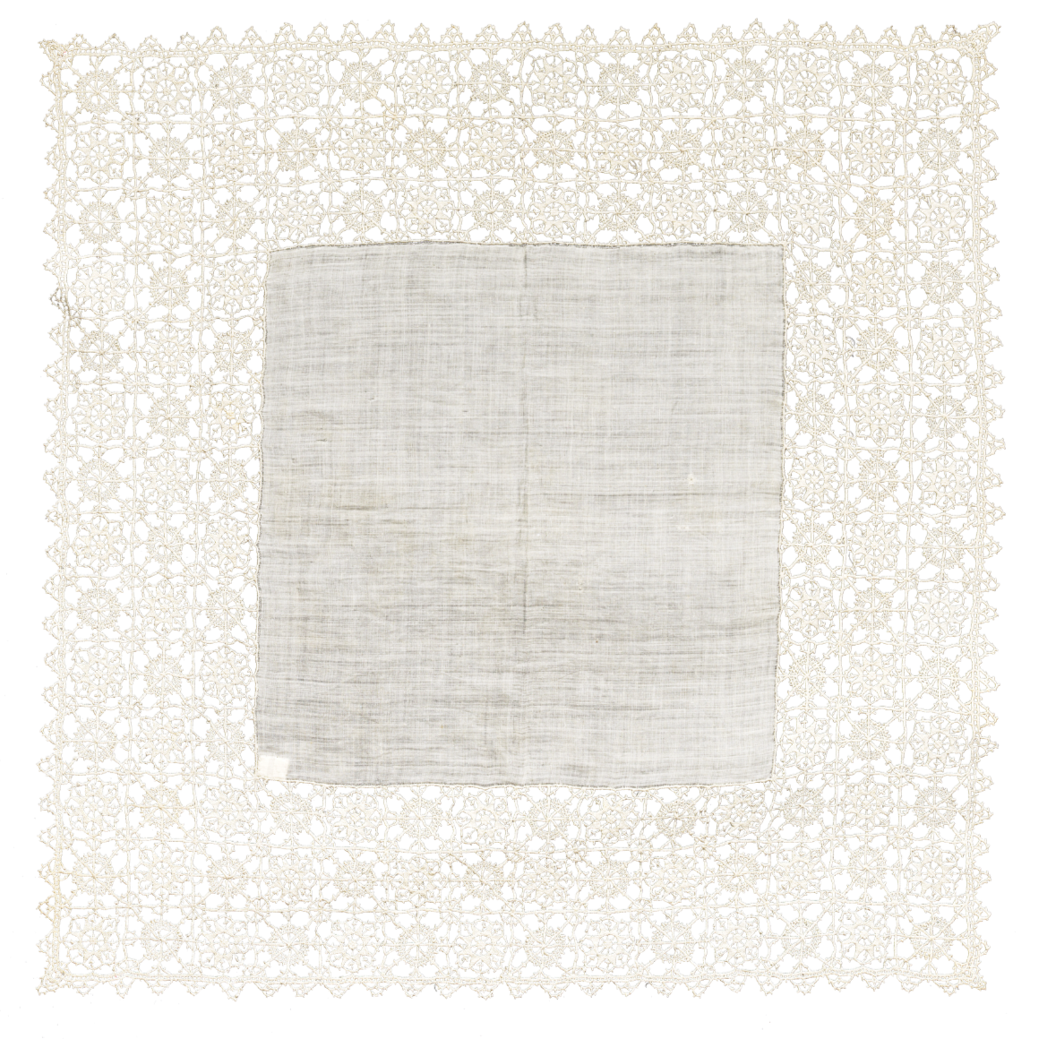 An intricate, square lace doily with a solid cloth in the center, featuring a detailed, floral lace border on a black background.