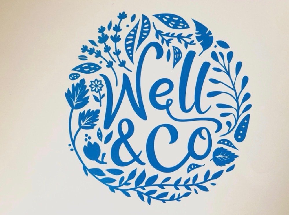 Blue circular sign with the text 'Well & Co' surrounded by floral and leaf illustrations.