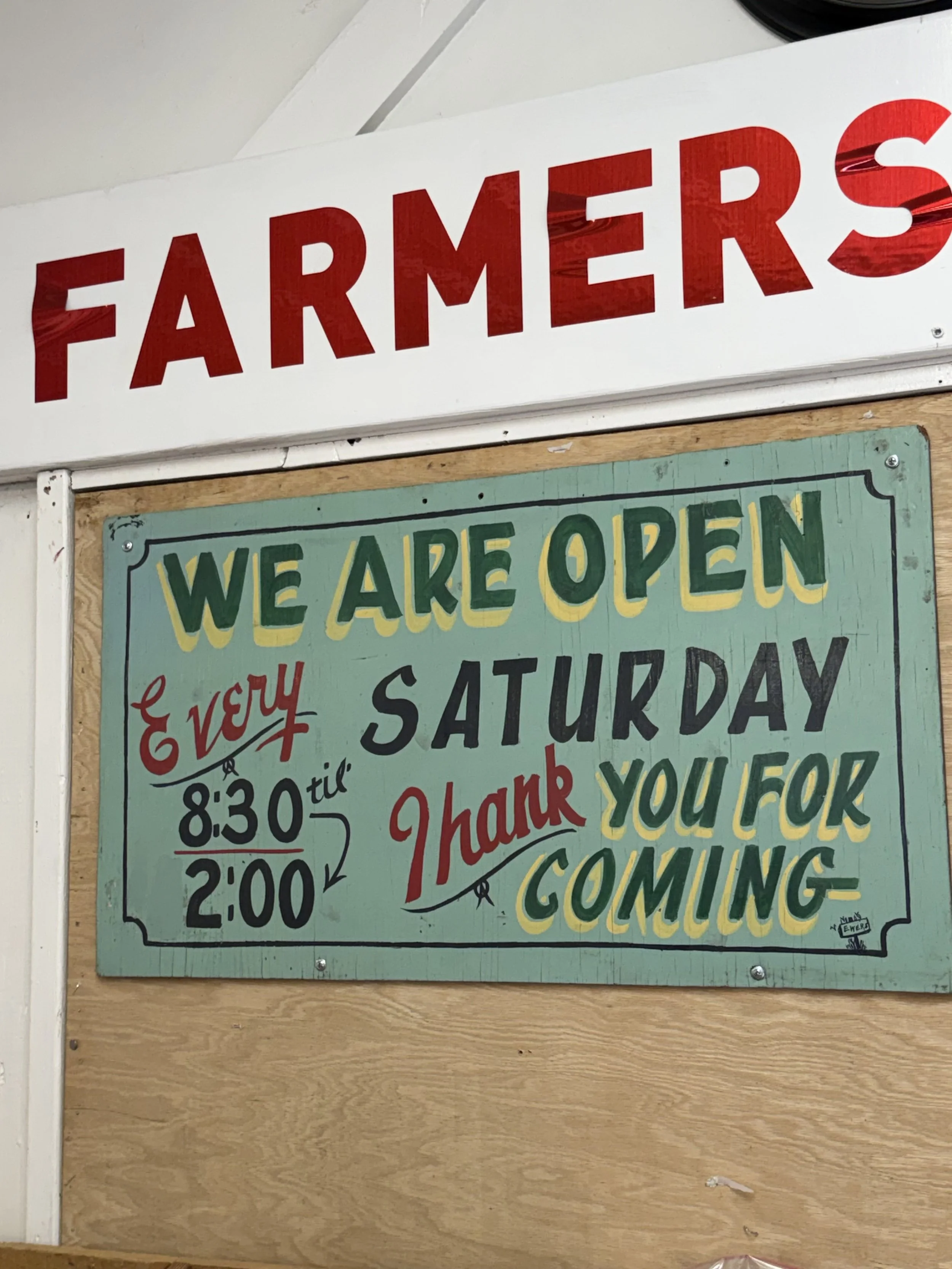 Sign with the words 'FARMERS' and a message about opening hours and closing time.