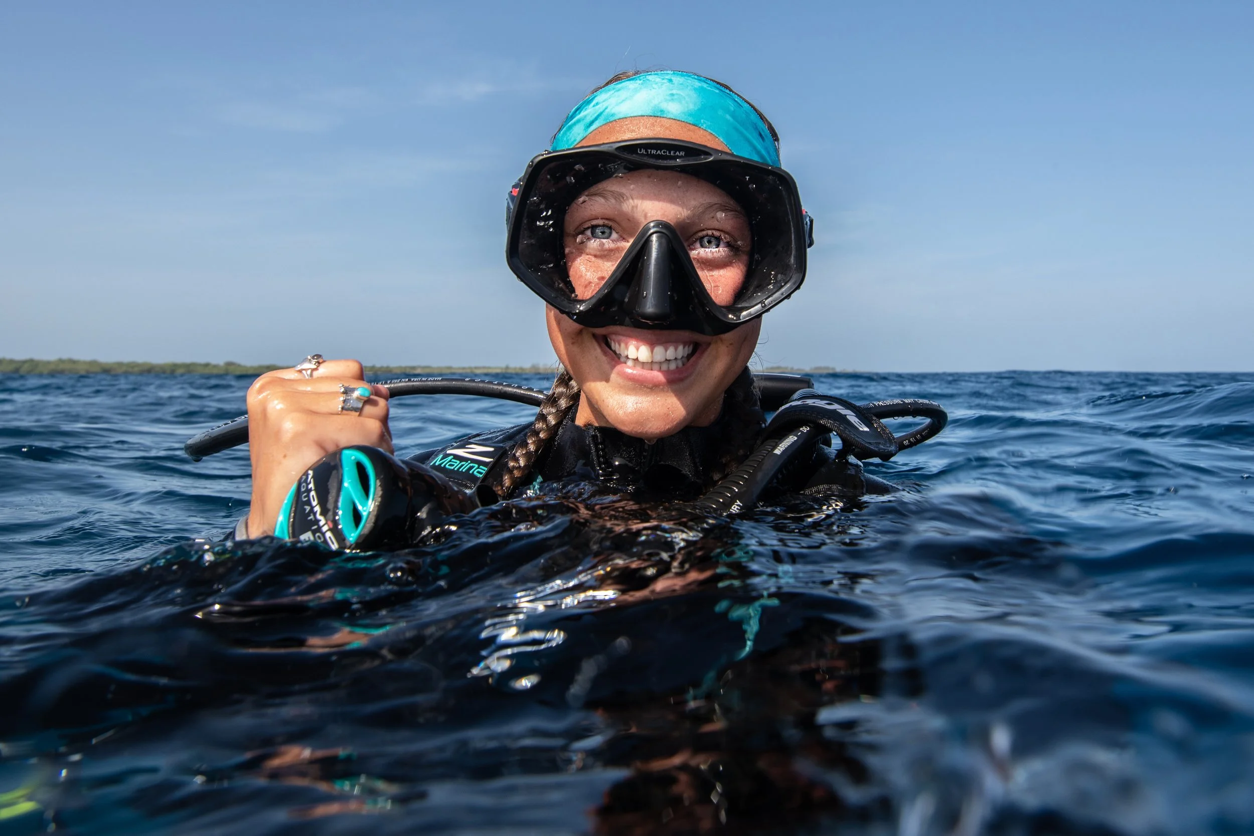 female scuba diver smiling at the camera on the surface