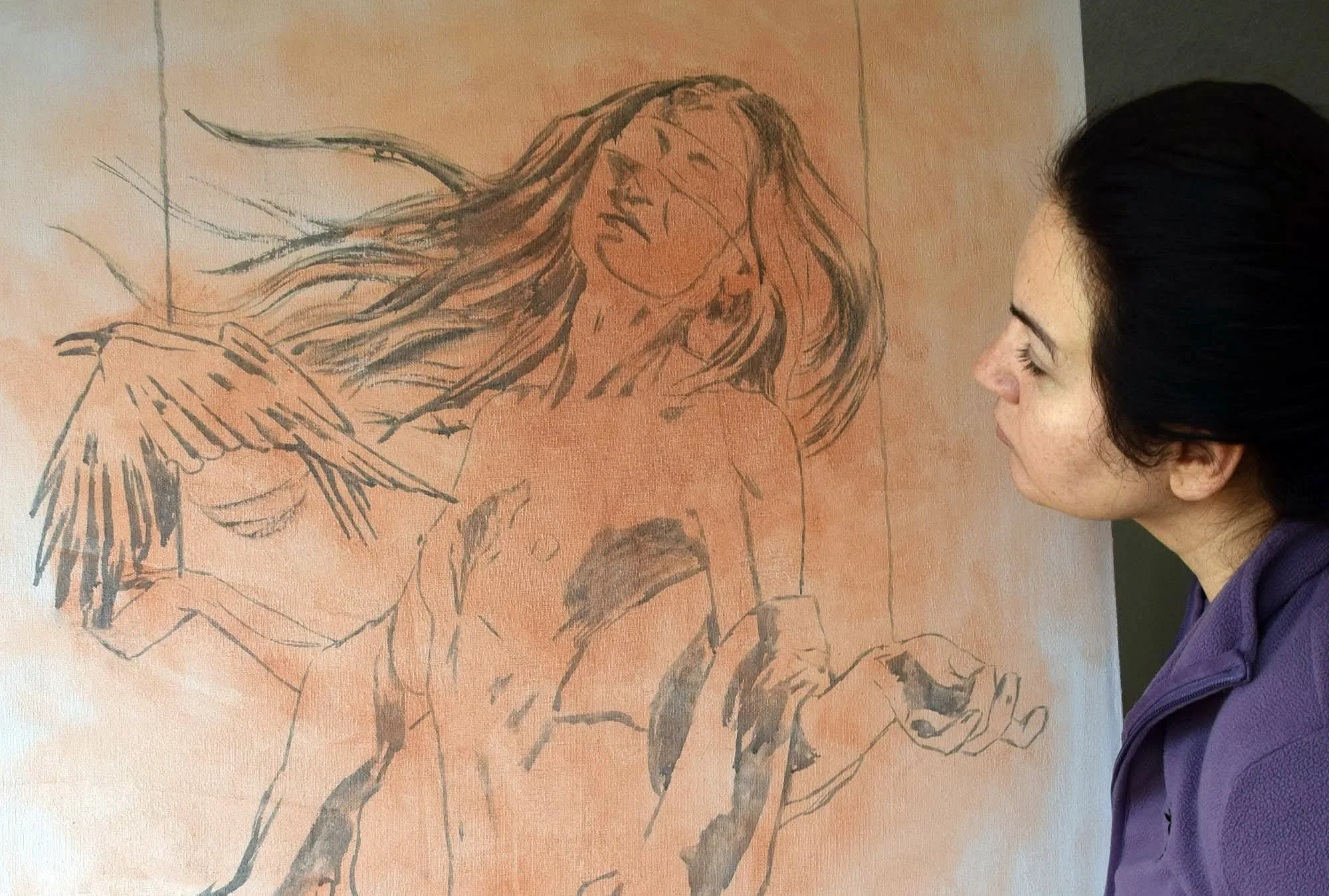 Nika Nyoko studying the initial drawing for a large figurative painting.