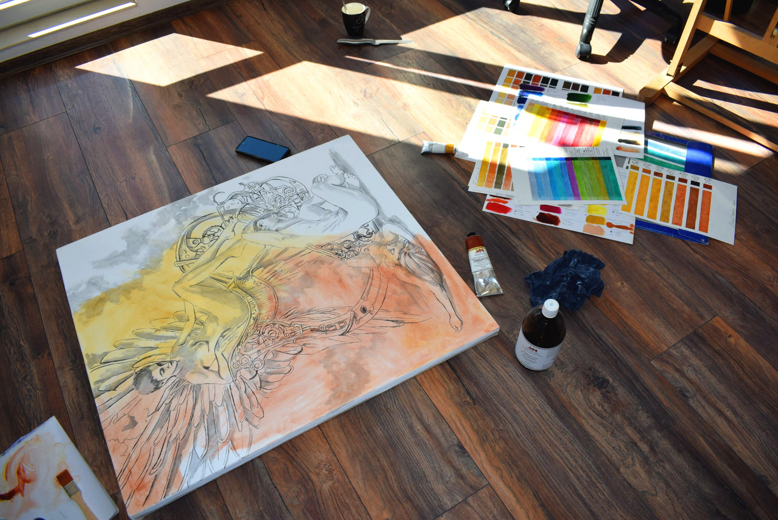 Artist's studio with a work in progress, paint brushes, oil paints and art materials.