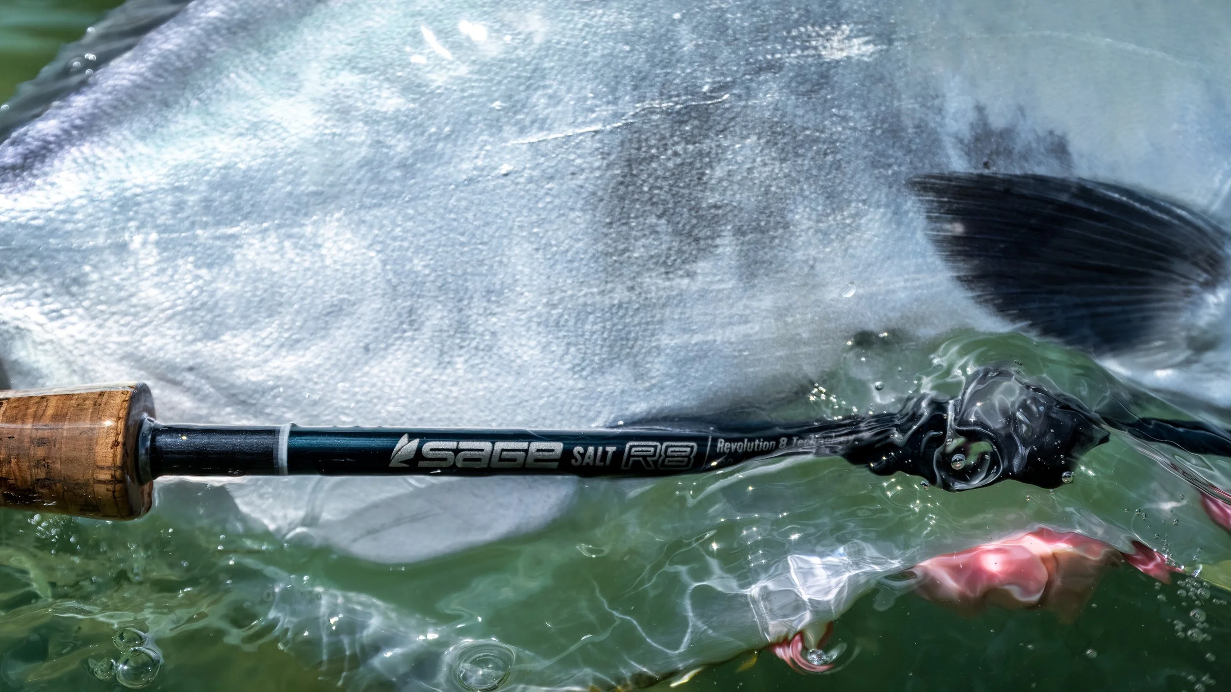 Close-up of a fishing rod in water, with water splashing around.