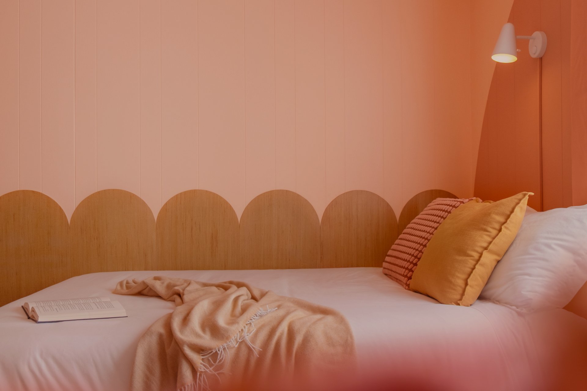 pink bedroom with curve panels, bed and pillows