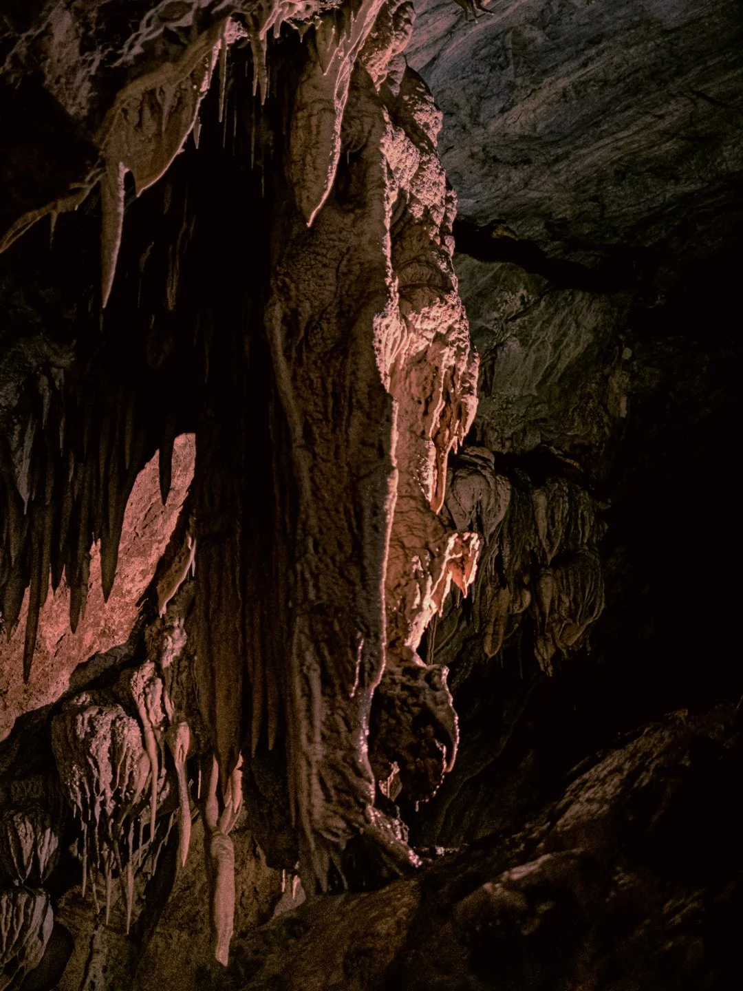 Stalactites and stalagmites inside a dark cave