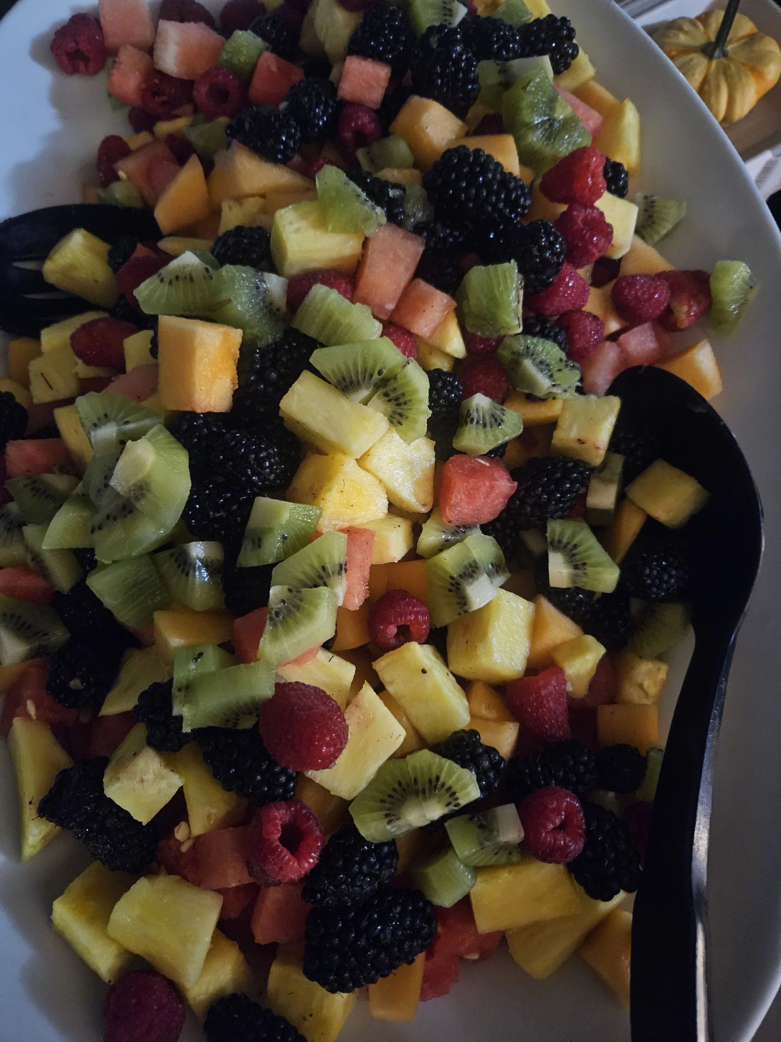 A bowl of freshly cut mixed fruit including blackberries, strawberries, kiwi, watermelon, cantaloupe, and honeydew melon.