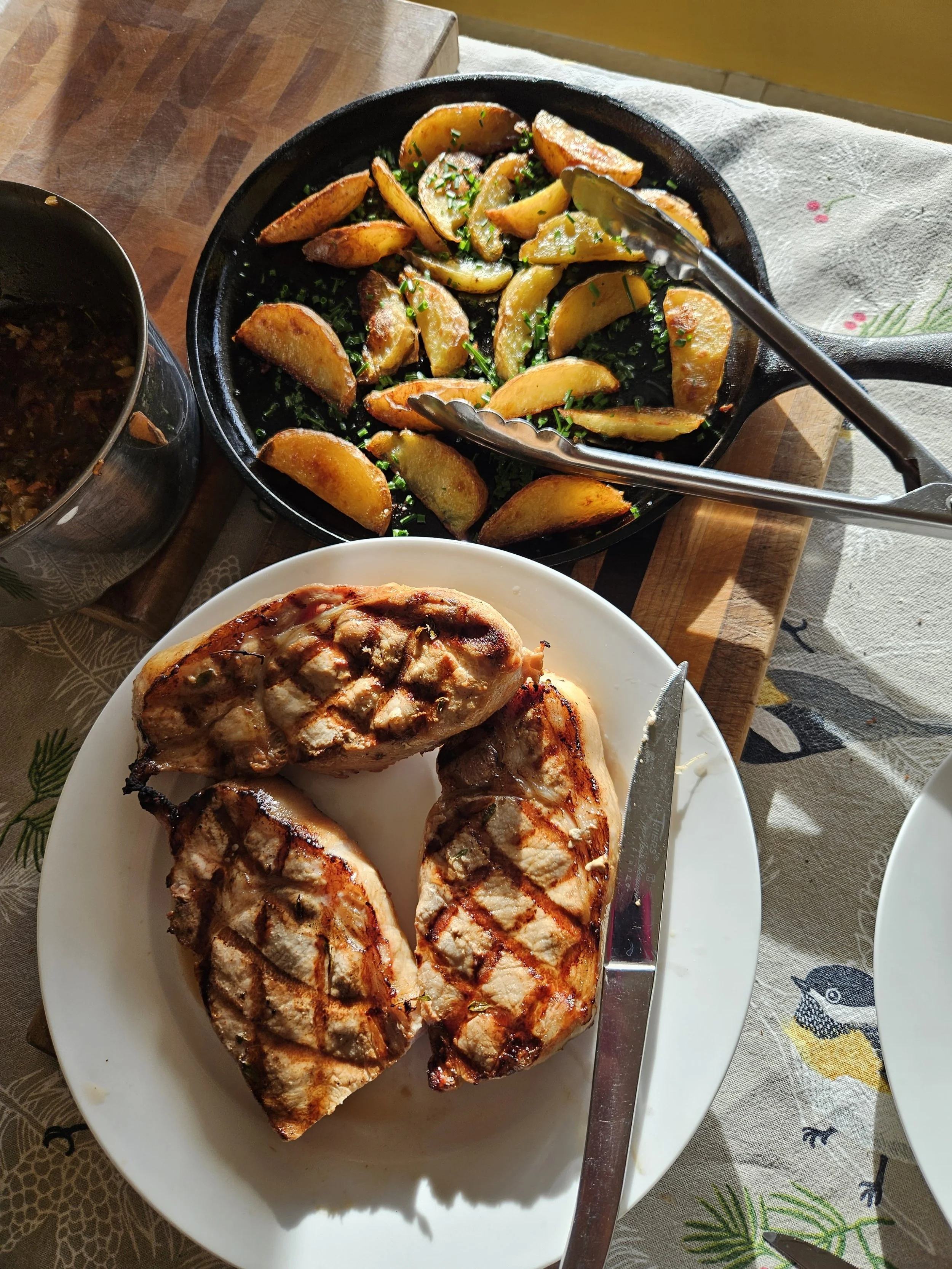 Plate of grilled chicken breasts with grill marks on a white dish.