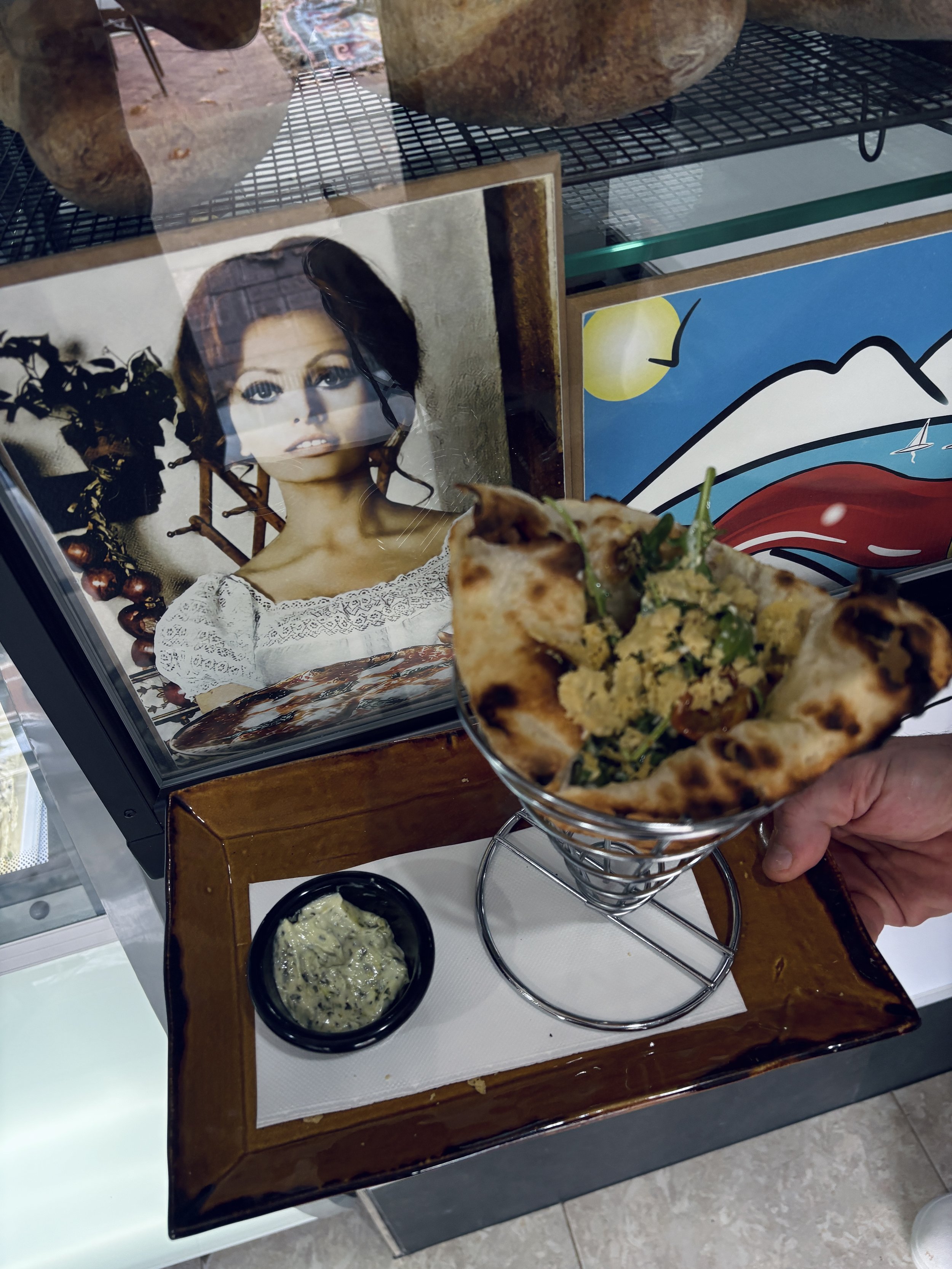A plate showing the lunch option Pulcinella.  A pizza sandwich is next to an image of Sophia Loren