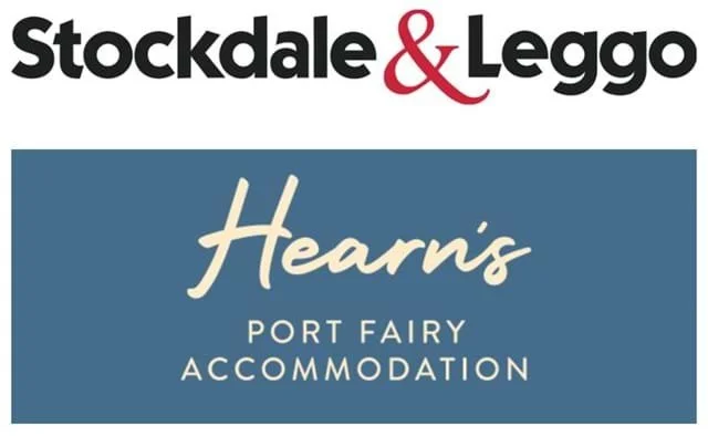 A promotional sign for Hearns, a port fairy accommodation, featuring the logos of Stockdale & Leggo and Hearns.