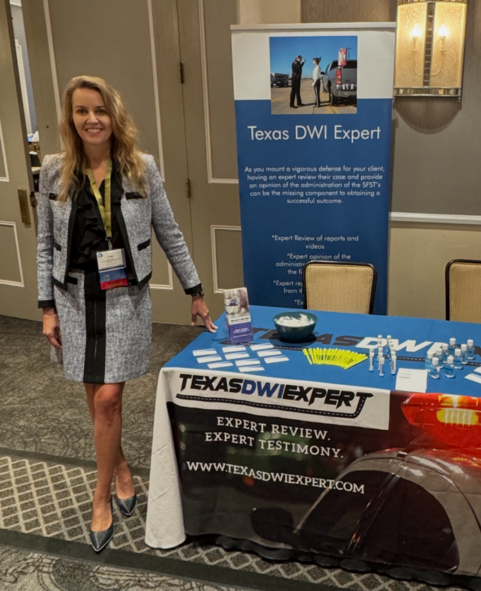 Lisa Martin standing beside her Texas DWI Expert conference booth