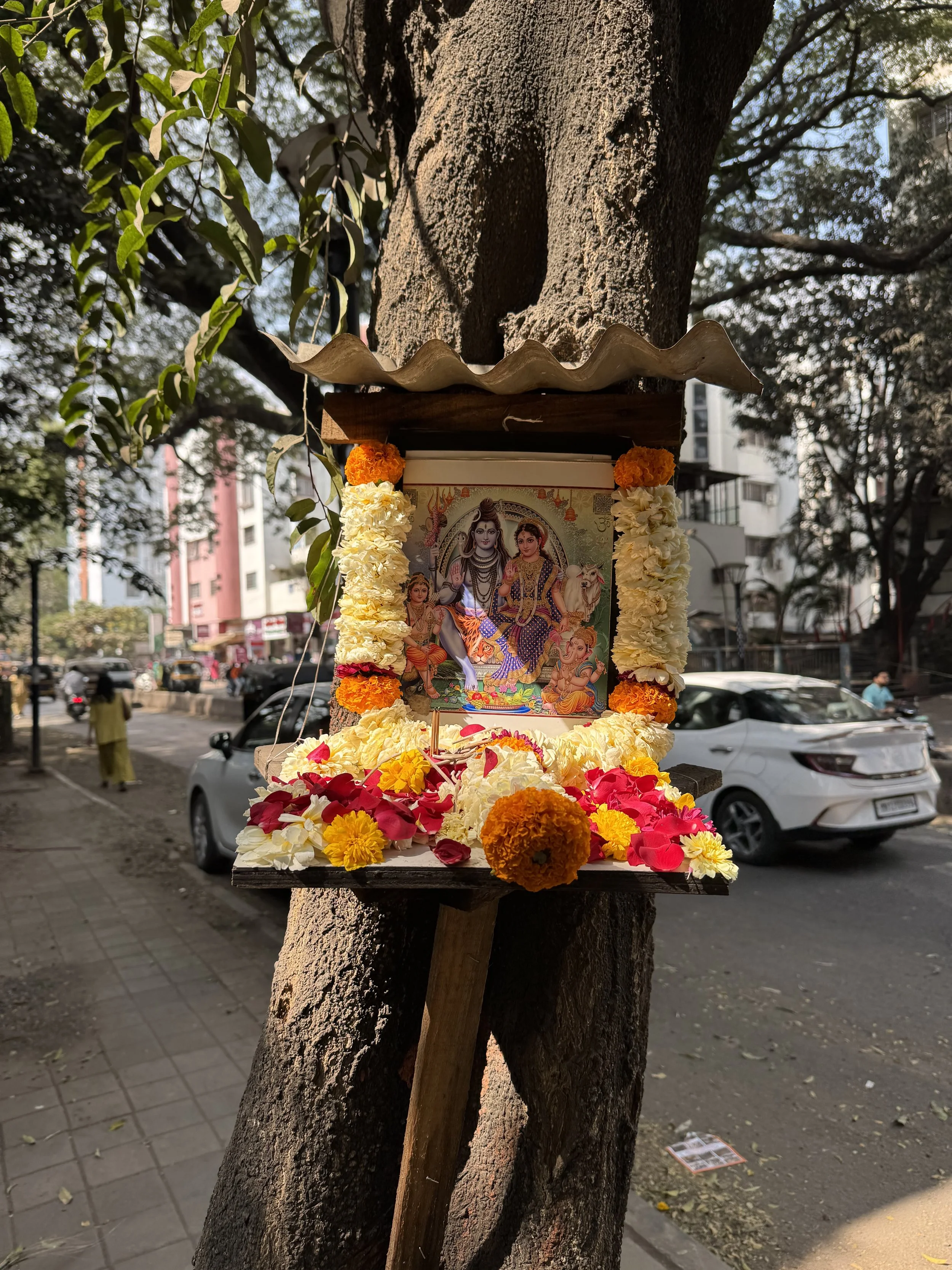 Image of a tree with a shrine on a street in Pune, India.