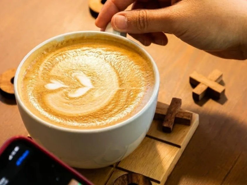 Cozying up to a latte while playing XO with a friend.