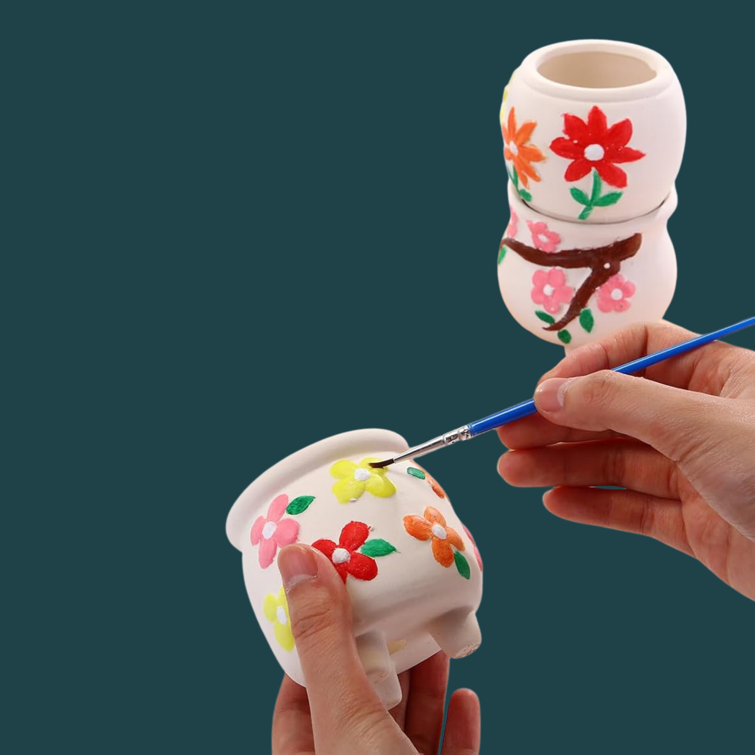 Hands painting a ceramic planter with a floral design
