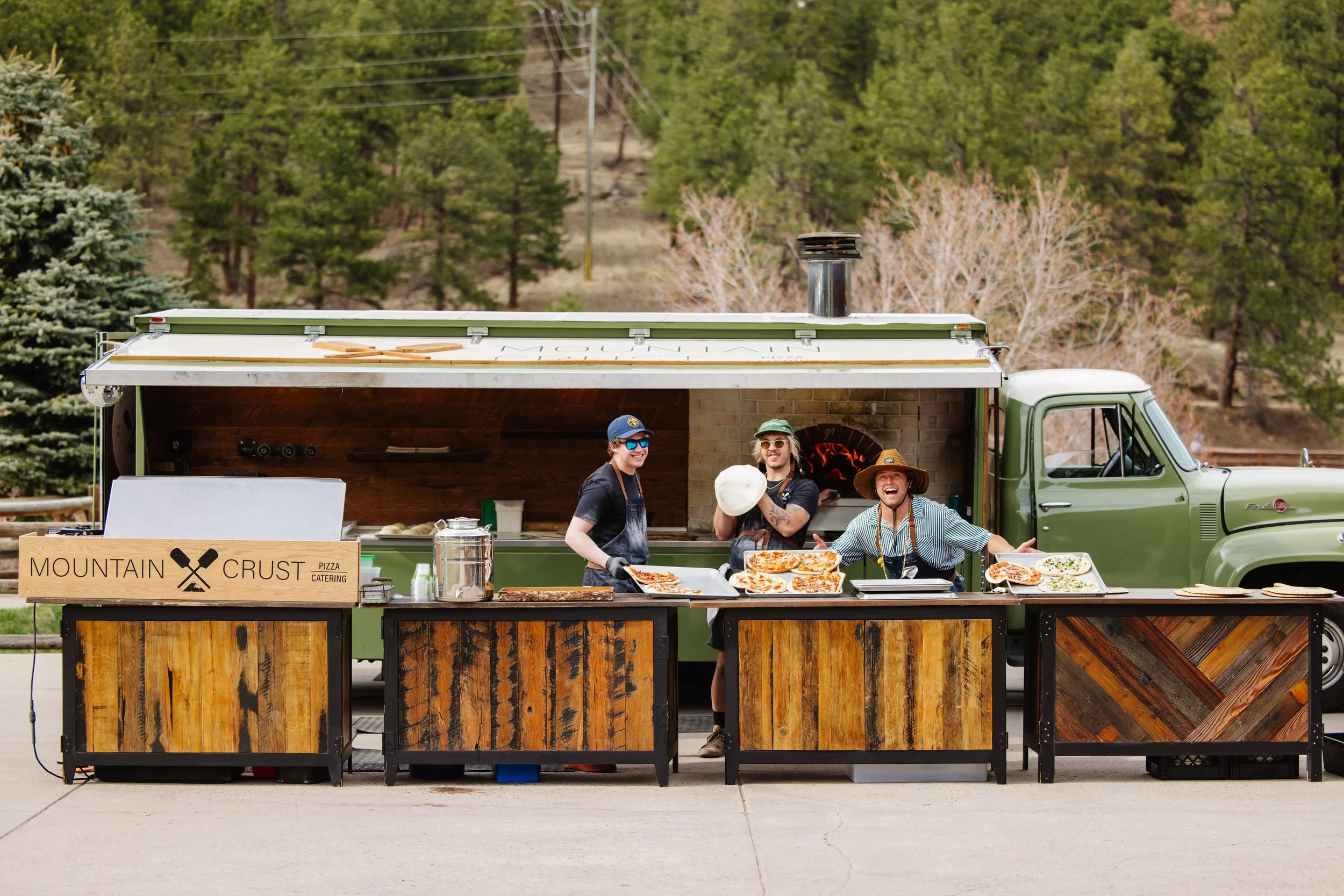 Mobile pizza catering setup with chefs preparing fresh pizzas outdoors at a Colorado mountain property