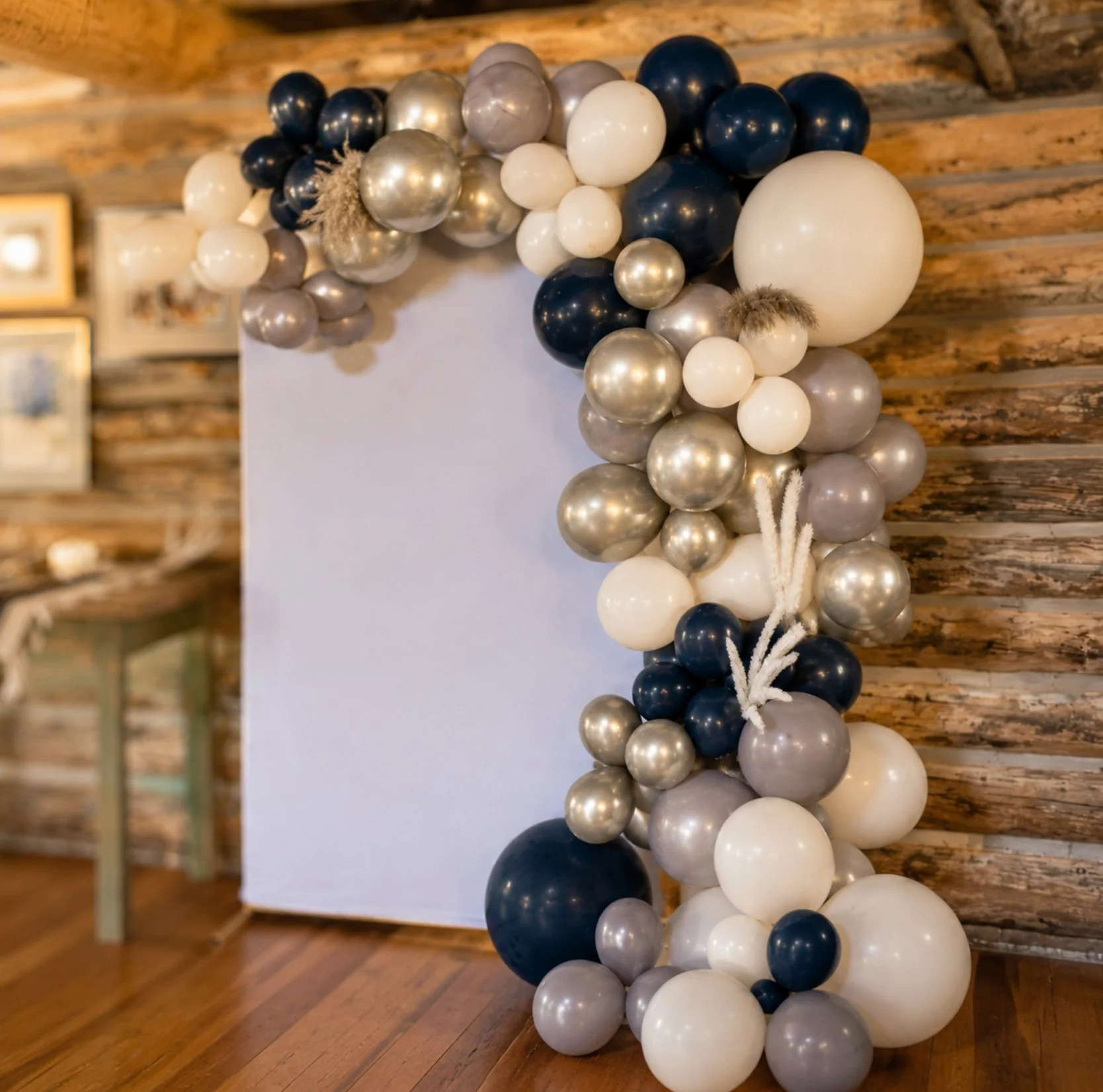 Neutral black, champagne and ivory balloon garland with a custom event backdrop