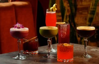 Variety of artisanal craft cocktails on a table at By The Wayside cocktail bar and lounge in East End Houston