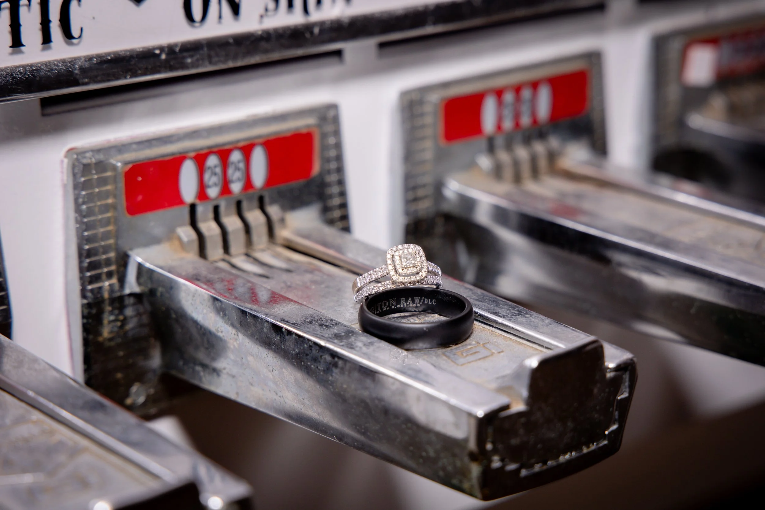 A close-up of a vintage cash register with a ring and a black band displayed on top of it.