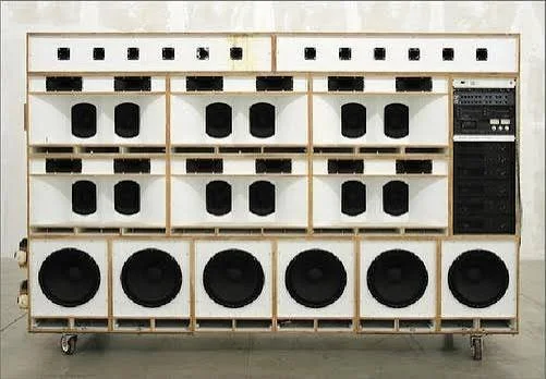 Large white speaker cabinet with multiple black speakers and a control panel on the right side.