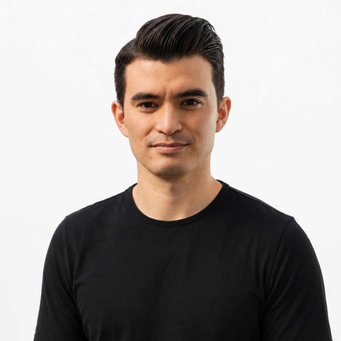 Close-up of a young man with dark hair, smiling, wearing a black shirt