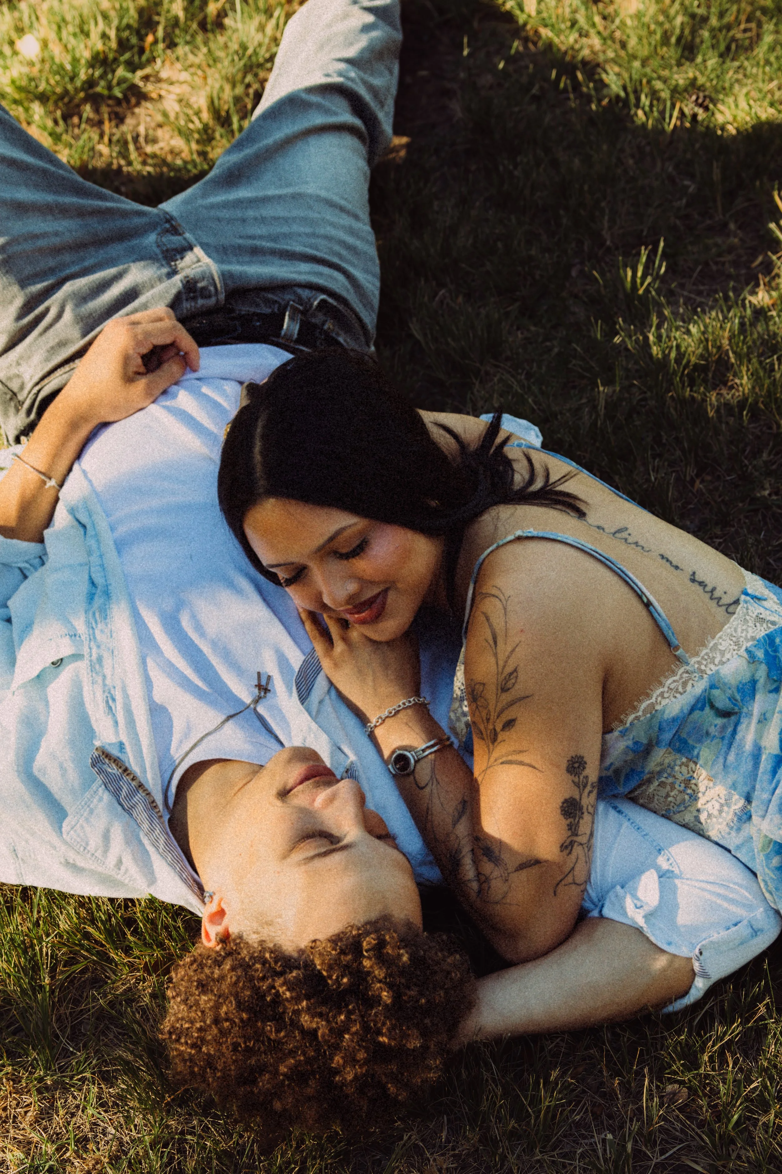 Two women lying on the grass and cuddling.