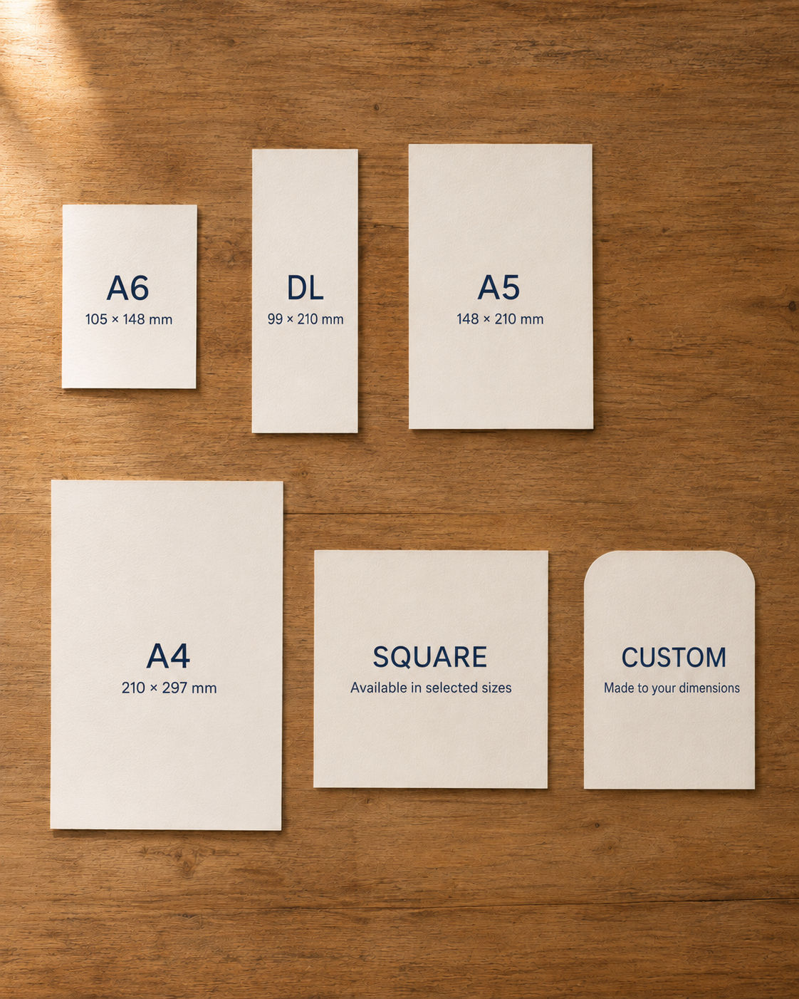 Cards showing different paper sizes, including A6, DL, A5, A4, square, and custom dimensions, arranged on a wooden surface.