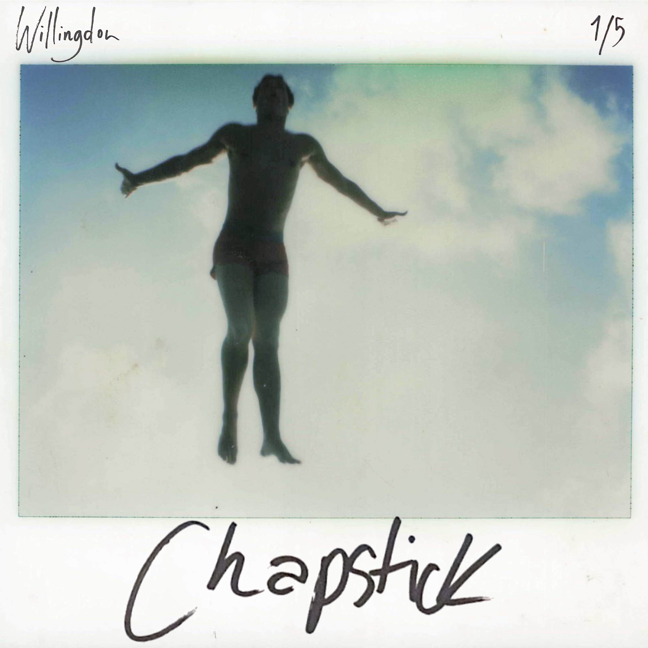 A photograph of a person with outstretched arms with a blue sky and clouds in the background, captured in a free-spirited pose.
