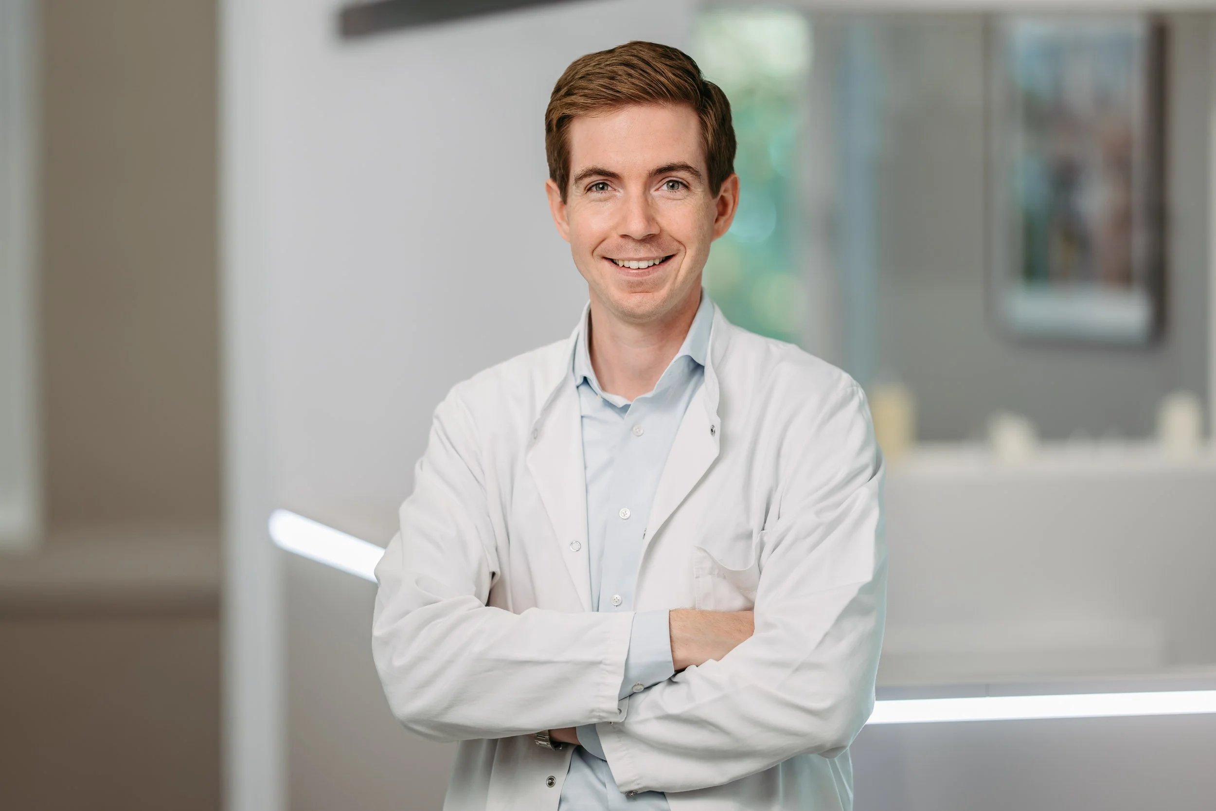 Priv. Doz. Dr. Maximilian Pallauf im Arztkittel im Wartebereich, Urologe und Androloge in Salzburg.