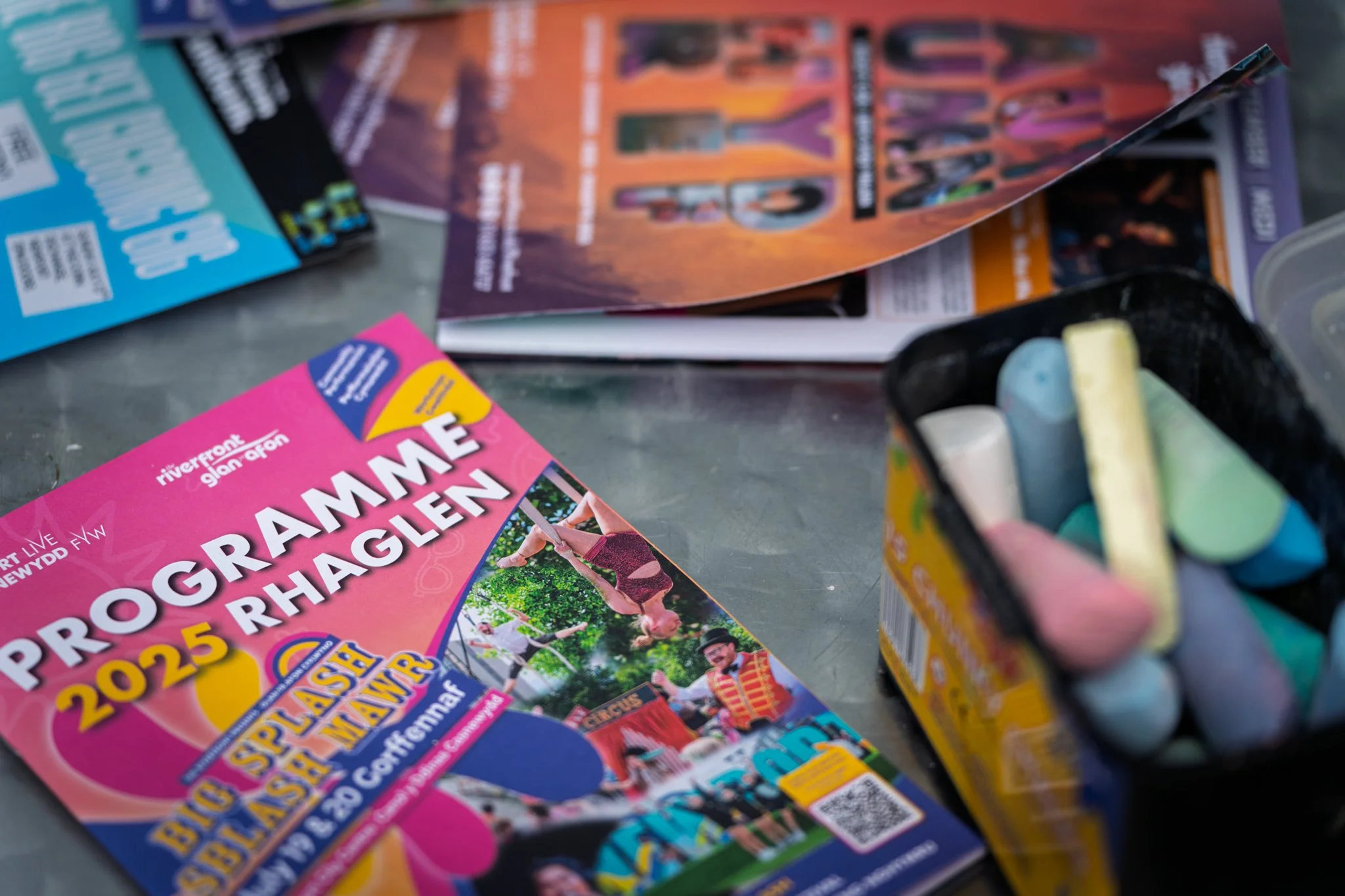 Colorful brochures for a community event with images of people and text about programs and activities.