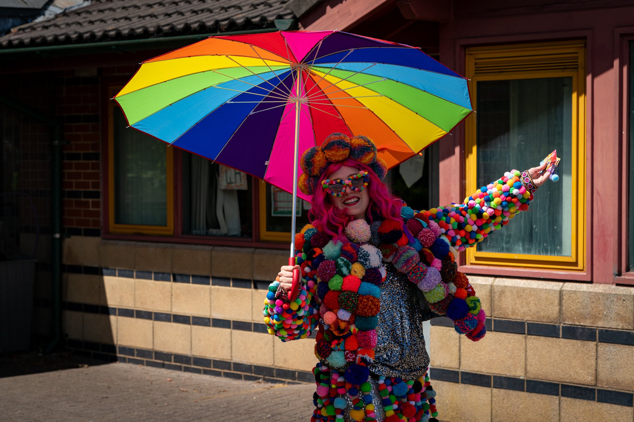 Woman with rainbow umbrella and colourful outfit.