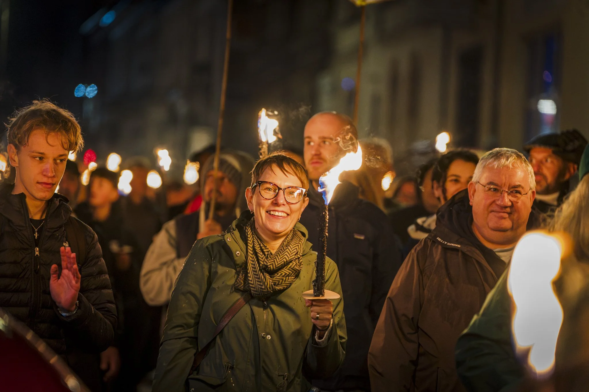 People holding candles and sparklers during a nighttime event or protest.