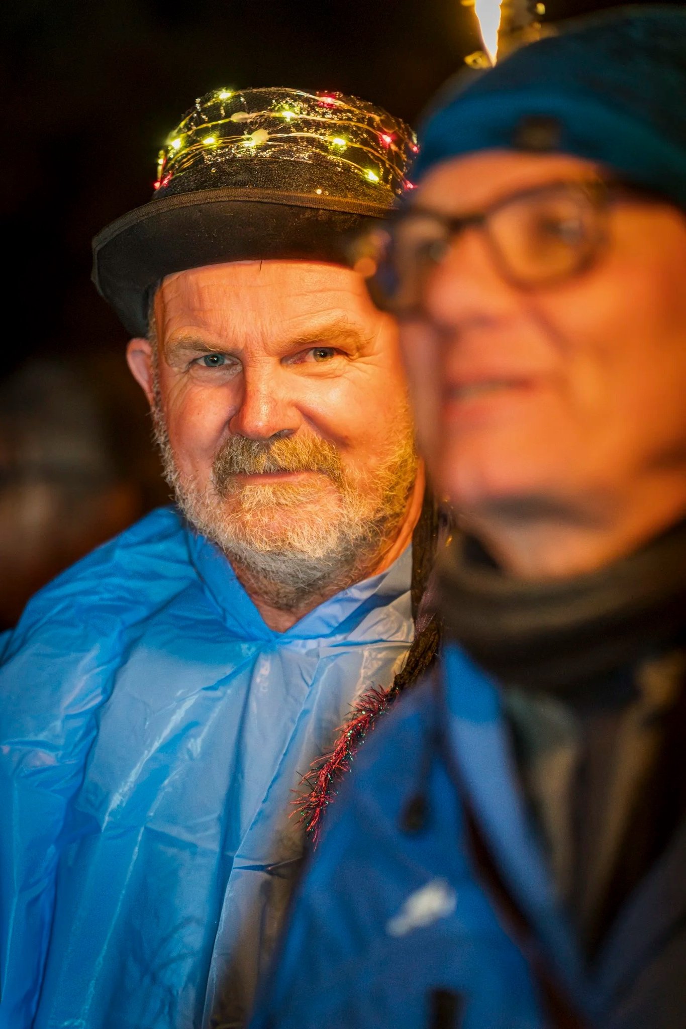 Smiling man in a light-up hat at Newport Rising festival, event photographer