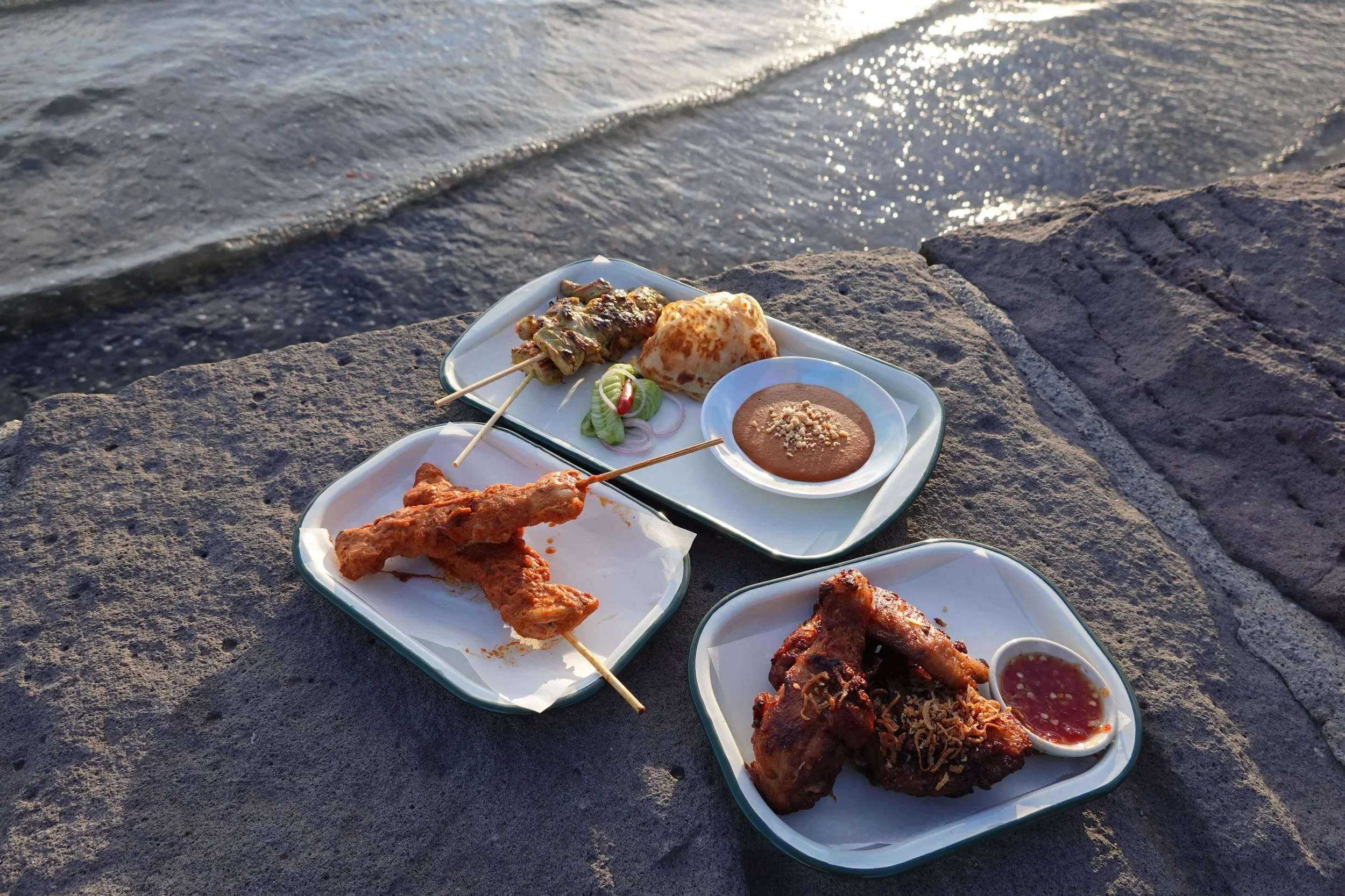 Southern Thai fried chicken, skewered satay, a pan fried roti, peanut sauce, and coconut curry marinated chicken skewer by the beach