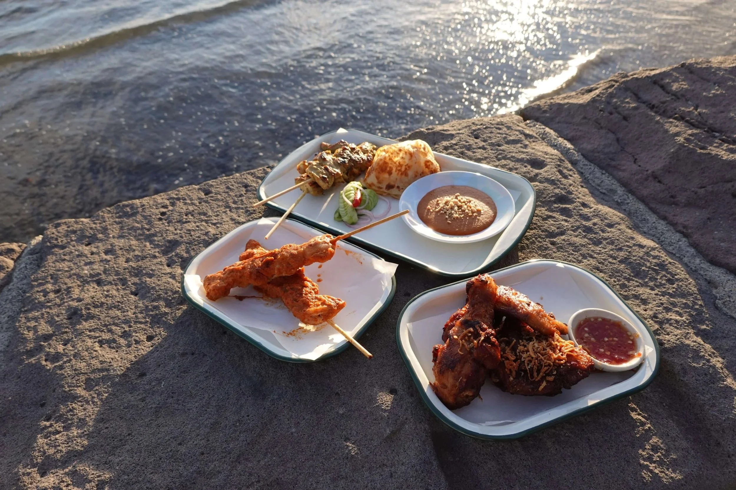 Southern Bird's Hat Yai fried chicken, Kolae skewers and Satay skewers with peanut dipping sauce, served outdoors by the water in St Kilda Melbourne. Southern Thai food in St Kilda.